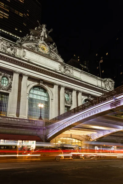 The Glory of Commerce sculpture adorns the exterior of Grand Central Station, New York City in the United States of America.  Passing traffic is captured by the colourful light trails.