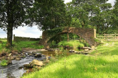 Batı Yorkshire Kırsal Bölgesi. İngiltere 'nin kuzeyindeki Haworth köyüne yakın Batı Yorkshire kırsalında taştan bir köprü geçmektedir..