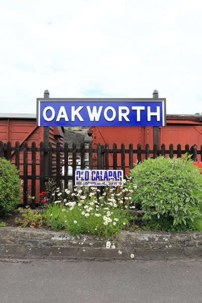 İngiltere 'deki Keighley ve Worth Valley Demiryolu' ndaki Oakworth İstasyonu için bir işaret. İstasyon, Demiryolu Çocukları filminde kullanıldı..