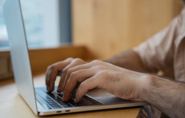 Çevrimiçi olarak çalışan ve klavyede yazan serbest yazar metin yazarlarının ellerini kapat. İşadamı dizüstü bilgisayar ve internet kullanıyor, web sitesinde bilgi arıyor, ofisinde oturuyor