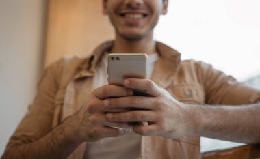 İnternet sitesinden yemek siparişi vermek için cep telefonu ve mobil uygulama kullanan erkeklerin ellerini kapat. Cep telefonu tutan mutlu Asyalı adam, sohbet ediyor, kısa mesaj alıyor, bilet ayırtıyor, ellerine odaklanıyor.