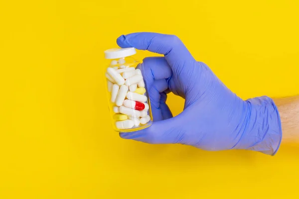 male doctor hand in gloves holding bottle with capsule pills isolated. online order prescription from pharmacy. safe contact less medicine delivery. pharmaceutical business. Copy space mock up