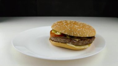 Beyaz tabakta hamburger ve patates kızartması.
