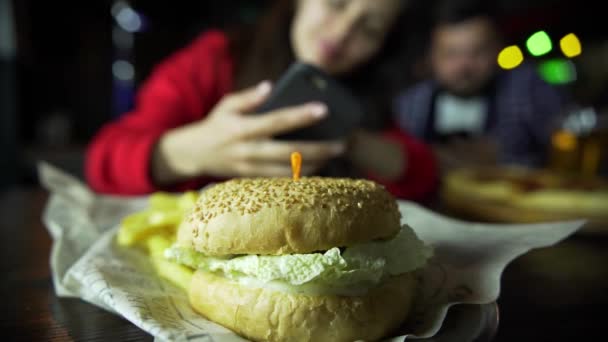 Bir Kız Bir Adam Fotoğraf Üstünde Senin Smartphone Burger Barda — Stok video
