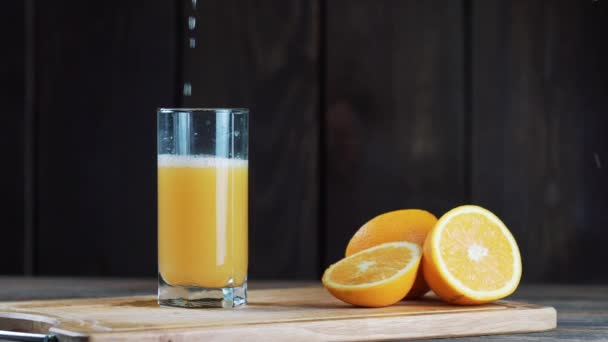 Färskpressad Apelsinjuice Ett Glas Hälla Pressa Apelsinjuice Trä Bakgrund Videoklipp