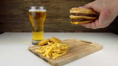 Erkek, iştah açıcı olmayan bir hamburgerin içine kolesterolü yüksek ve doymuş