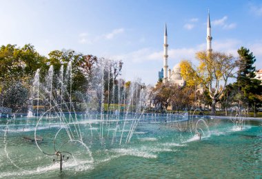 Konya Kultur Parkı 'ndaki çeşmelere bakın. Arka planda bir cami ve altın sarısı sonbahar doğası..