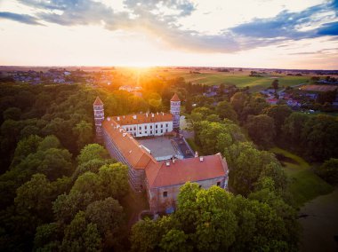 Historical Panemune castle in dramatic sunset conditions with green nature and sun flare in a countryside of Lithuania. Aerial view.