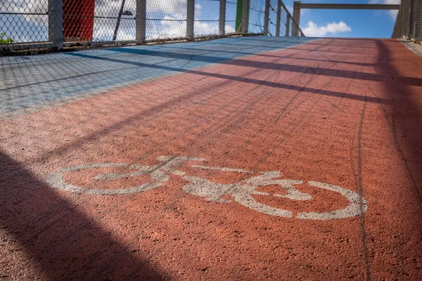 Bicycle logo on the red track ground up the hill in bicycle academy in Europe. BAckground image with blank space.