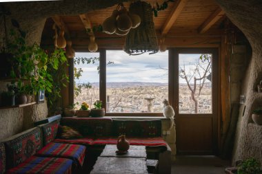 Mağaranın içinde ev eşyaları ve pencerenin yanında oturan kediyle birlikte. Geleneksel Kapadokya mağarasının içinde yaşamak için.