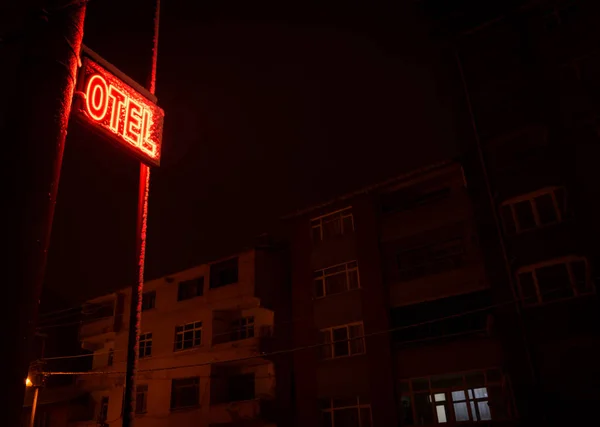 Otel sign at night in Akkus town hotel in Turkey.  Living buildings in the background.