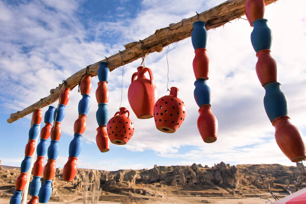 traditional hand made blue and brown pots with writings are hanging on the wires in a countryside of Cappadocia. Hobbies and traditions in Turkey.