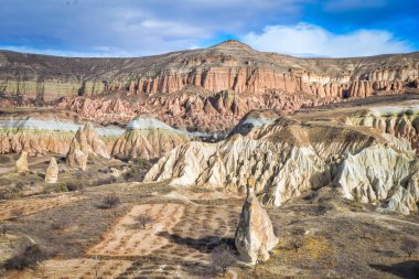 Bulutlu bir günde insanların olmadığı bir sürü renkli vergiyle Rose Valley 'in kayalık manzarası. Kapadokya 'nın jeolojik oluşumları.