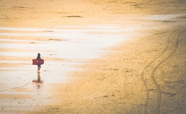 サーフィンボードを持つビーチの女性は — ストック写真