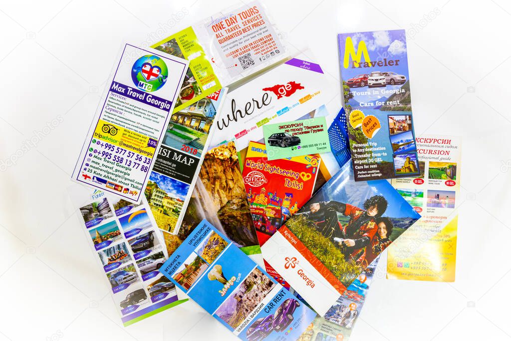 Many Travel in Georgia leaflets, brochures, booklets and adverts spreaded on the white background. Concept of promoting travelling in Sakartvelo. Georgia. Tbilisi.2020