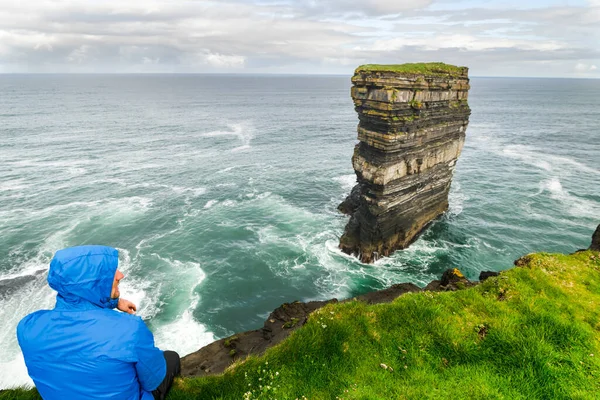 Τουρίστας Μπλε Σακάκι Κοιτάζει Κεφάλι Των Ντάουνπατρικς Στη Βόρεια Ιρλανδία — Φωτογραφία Αρχείου
