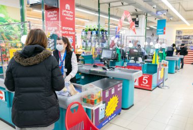 Carrefour tezgahtar ve müşteri kasasında. Karantina sırasında alışveriş kavramı ve yeni güvenlik yönetmelikleri. Tiflis. Georgia. 25.03.2020.