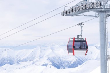 Boş beyaz / kırmızı kapalı kayak asansörü kabini ve arka planda beyaz dramatik dağlar. Sezon sonu konsepti. Gudauri. Georgia.2020