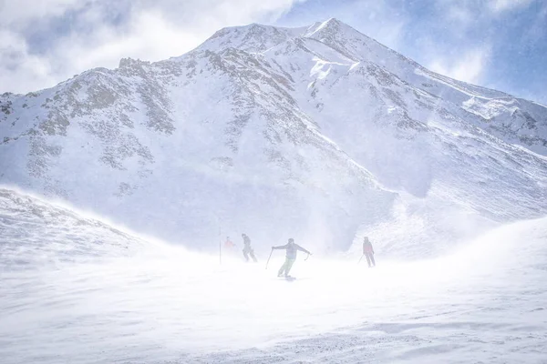 Grupo Esquiadores Rapidamente Esqui Descendo Colina Com Enorme Montanha Fundo — Fotografia de Stock