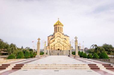 Tiflis 'teki kutsal üçleme katedralinin arka planda duran katedralli fotoğraflarını çeken bir turist. Georgi 06.03.2020