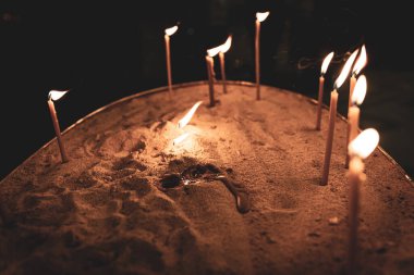 Kumda yanan üç küçük mum kilisenin içinde yanıyor. Bitiş ve umut kavramı. Kutsal Üçlemeci Katedrali. Tiflis. Georgia. 2020