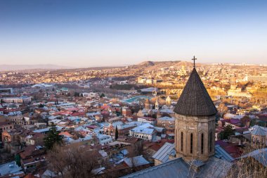 Tiflis 'teki Aziz George Katedrali' nin günbatımında Gürcistan başkentinin panoramik manzarası. 2020