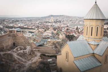 Narikala kilisesi, arka planda kale duvarları ve şehir manzarası olan bir yer. Tiflis 'teki mimari ve tarihi yerler. Georgia..