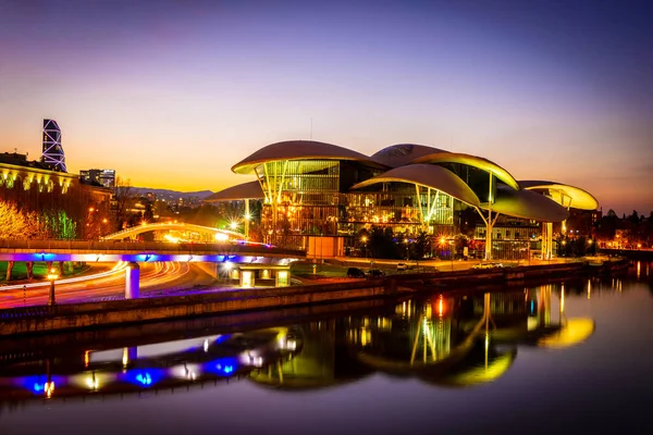Mtkvari nehri geceleri Tiflis 'teki kamu hizmetleri binasının ve sokakların yansımalarıyla doludur. Georgia 'nın başkentinde seyahat ve mimarlık. 09.04.2020