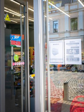 Spar süpermarket vitrinlerinde maske takmak ve çalışma saatlerini değiştirmek hakkında uyarılar var. Dükkanların yeni kısıtlamaları ve yönetmelikleri. Tiflis. Georgia. 20.04.2020