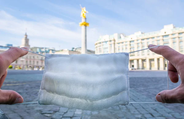 Dvě Ruce Držící Bílou Obličejovou Masku Nad Pomníkem Svobodné Sochy — Stock fotografie