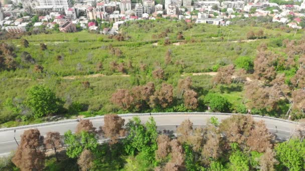 Lucht uitzicht op de weg met een auto en Vake district wolkenkrabbers in Tbilisi. Concept van het stadsleven in de Kaukasus en toerisme in Georgië. 2020 — Stockvideo