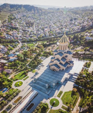 Tiflis 'teki ortodoks kutsal kilisesi 4' ün etrafında bir sürü hortum ve çiçek açan bahar ağaçları var. Din ve Kartacalıların kültürü. Sakartvelo.11.04.2020
