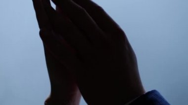 Karı ve kocanın elleri mavi su arka planında birbirine dokunup tutunuyor. Düğün günü karı ve kocanın ellerinin yakın çekimi.