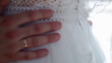 Karı ve kocanın elleri birbirine dokunuyor ve birbirlerine tutunuyorlar. Düğün günü karı ve kocanın ellerinin yakın çekimi.