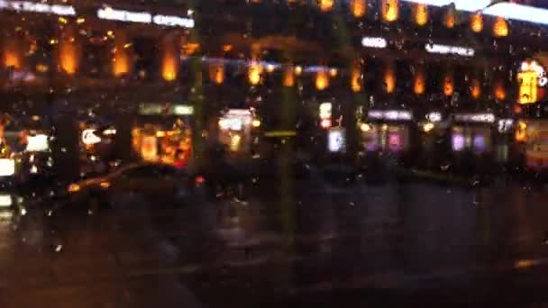 Defocused lichten en vervoer in de nacht stad straat terwijl het regent — Stockvideo