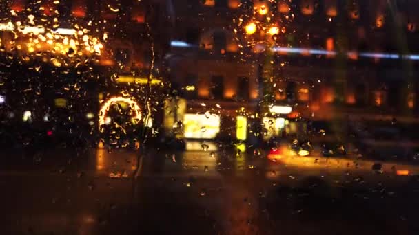 Defocused lichten en vervoer in de nacht stad straat terwijl het regent — Stockvideo
