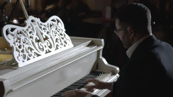En pianist närbild utför sin egen musik på publiken bakgrund — Stockvideo