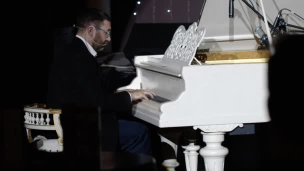 Ein Pianist hautnah, der seine eigene Musik im Hintergrundbild eines Nachtclubs spielt — Stockvideo
