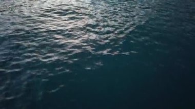 Gün batımında sakin deniz yüzeyi, alçak açılı görüş. Kış zamanı Akdeniz.