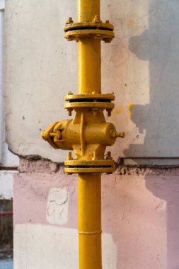 Borudaki sarı kapak vanası doğal gaz dağıtımını sağlar ve gerekirse kapatır. Vinçin yanındaki boru hattına bir flanj yerleştirildi. Eve yakın bir yerde.