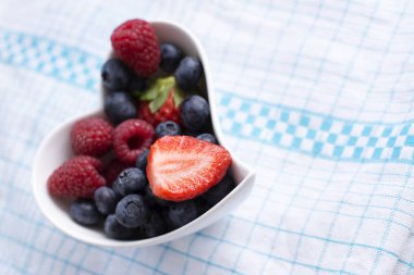 Beyaz bir klozete konmuş ahşap meyveler.