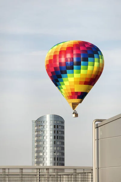 明亮的热气球在城市建筑中低空漂浮 适合进一步的照片操作 — 图库照片