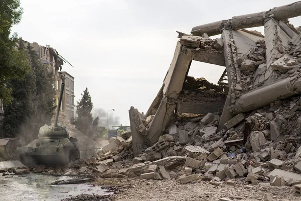 Tank among city ruins, collapsed concrete buildings. War scene