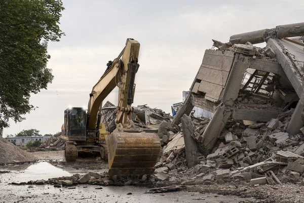 Edifício industrial desmoronado com uma escavadora enorme da pá — Fotografia de Stock