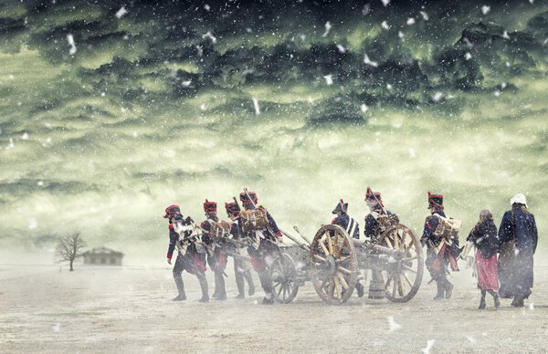 Наполеоновские солдаты и женщины маршируют в падающем снегу и вытаскивают пушку на равнине, в сельской местности с бушующими облаками. Солдаты направляются к поврежденному заброшенному дому. Возвращаясь домой
