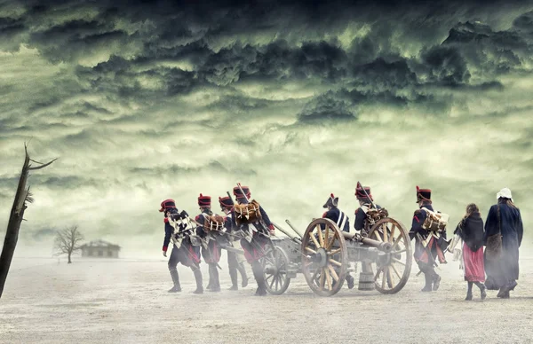 Napoleonic soldiers and women marching and pulling a cannon in plain land, countryside with stormy clouds. Soldiers going towards a damaged abonded house. Coming home.