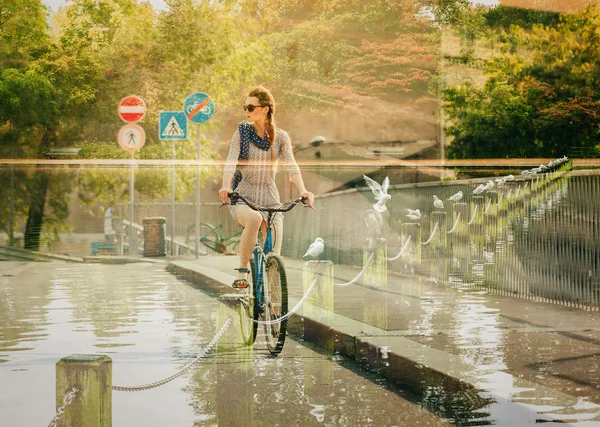 Double exposure of woman riding bike and autumn lakescape