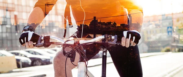 Dupla exposição do desportista andar de bicicleta e cidade pôr-do-sol silh — Fotografia de Stock