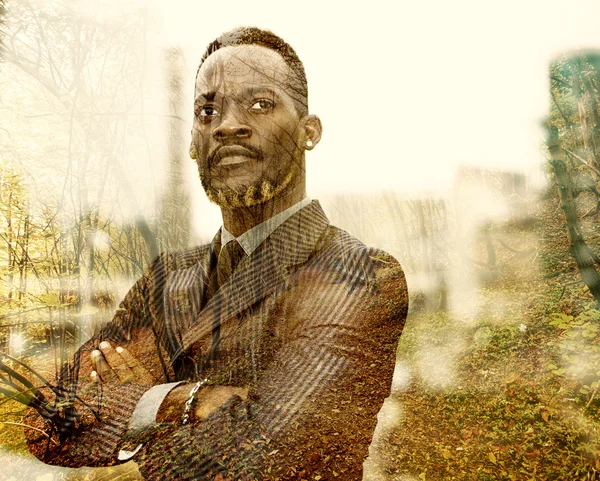 Двойная экспозиция африканского бизнесмена и осенний пейзаж — стоковое фото