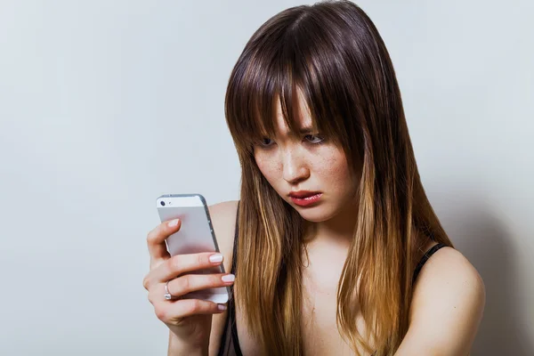 Pretty girl portrait looking at her smartphone — Stock Photo, Image